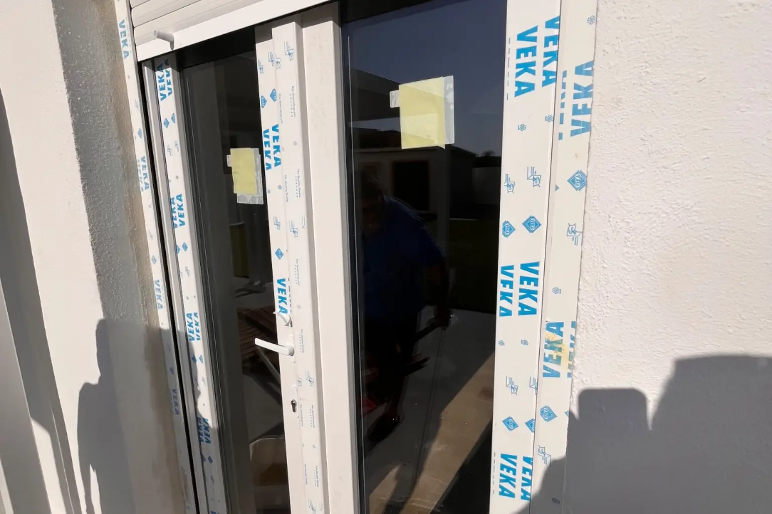 Ventana corredera de PVC recién instalada, con el plástico protector aún puesto